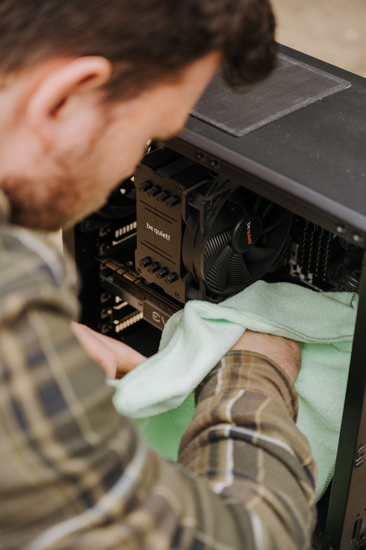 Technician servicing a refurbished desktop PC interior before sale